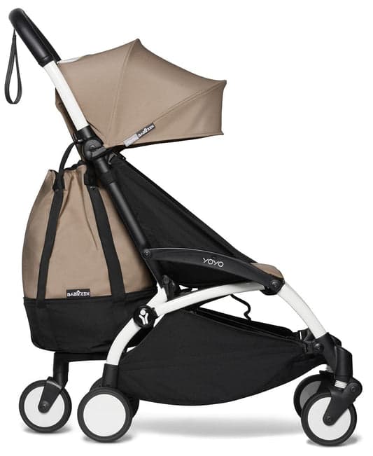 Babyzen YOYO3 stroller in white frame with navy color pack folded over shoulder at airport gate