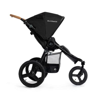 Bumbleride Speed jogging stroller in eco-friendly fabric on a paved trail surrounded by trees