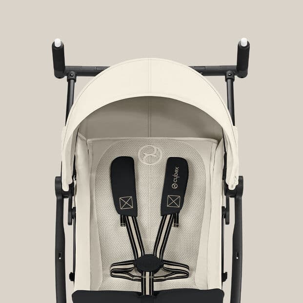 Cybex Libelle stroller folded to ultra-compact size next to an overhead airplane bin