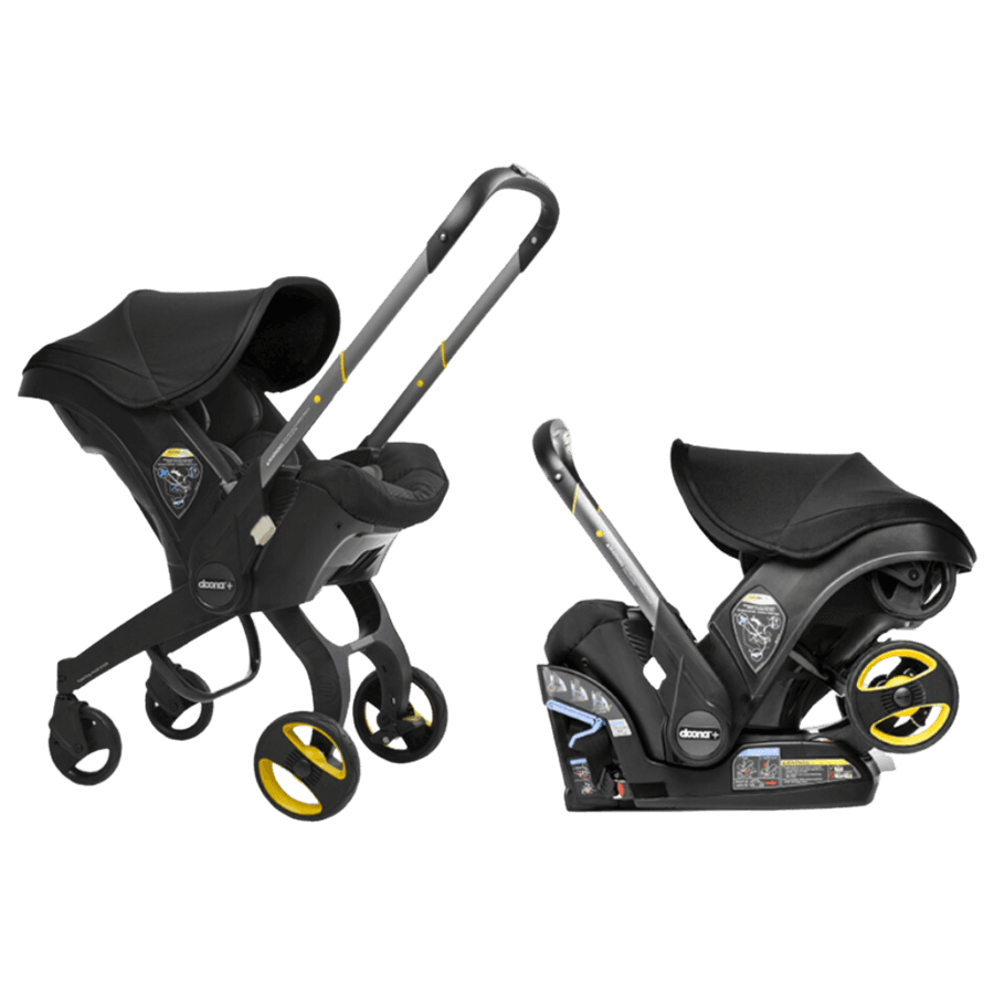 Doona+ car seat and stroller in black color with wheels deployed in stroller mode on an airport terminal floor