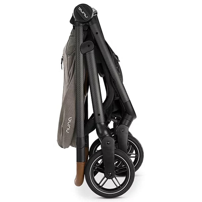 Nuna SWIV stroller in hazel tan with the rotating seat in forward-facing position on a city street