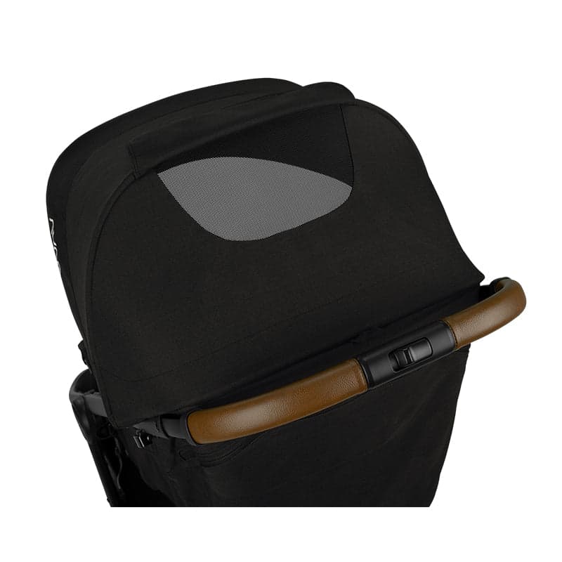 Nuna TRVL stroller in caviar color with carry bag on an airport concourse