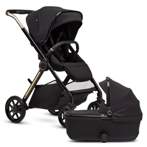 Silver Cross Reef 2 stroller in glacier white with bassinet on a park path