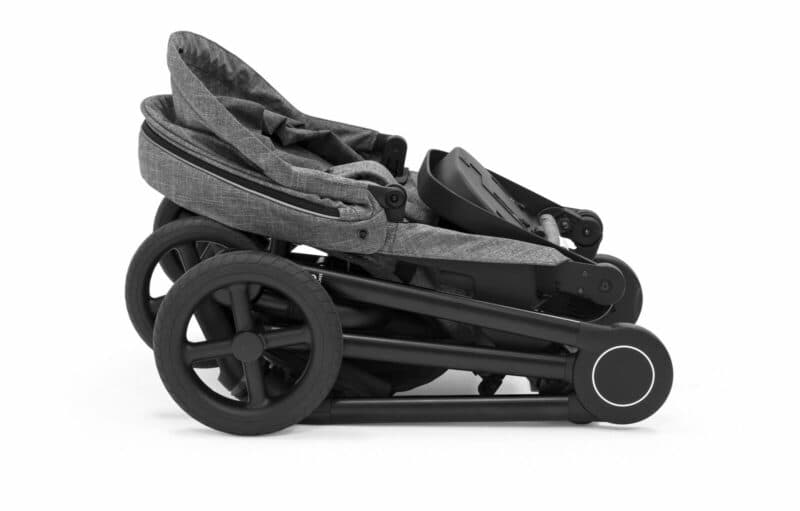 Stokke Beat stroller in black melange folded on a Scandinavian city street