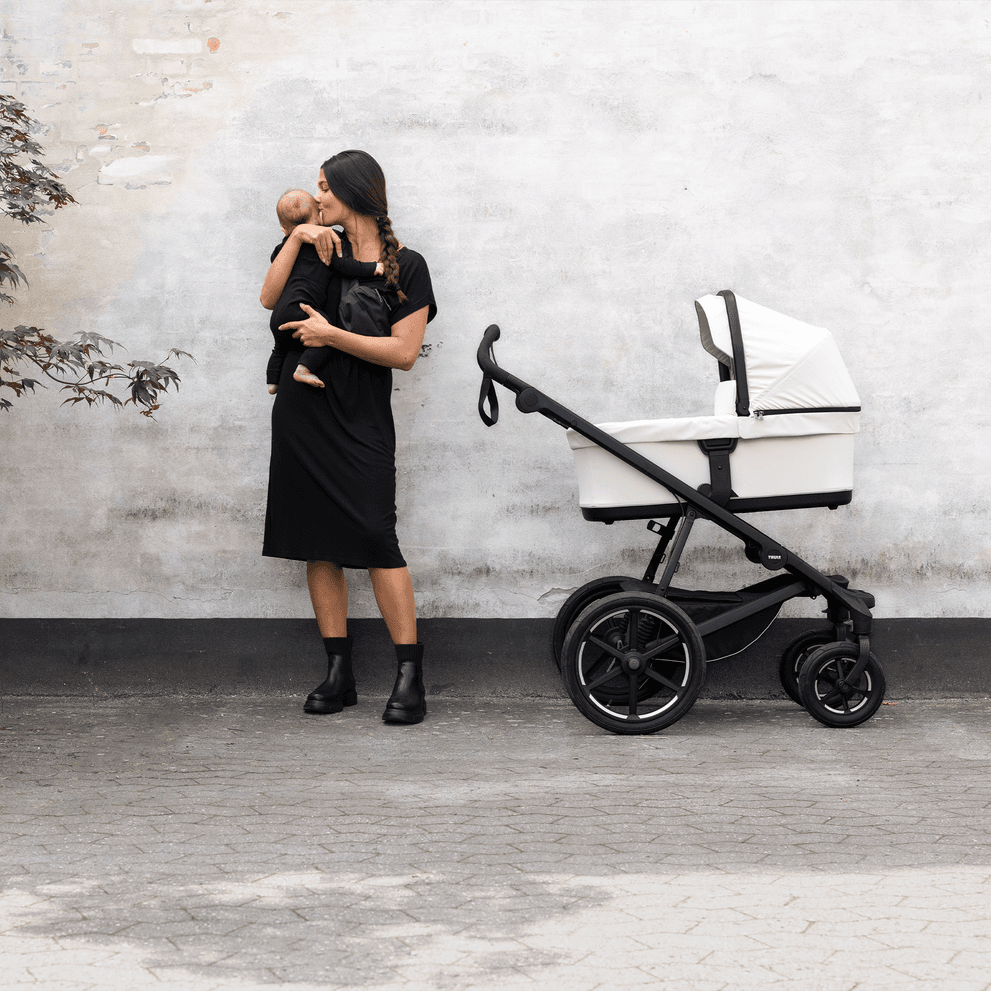 Thule Urban Glide 3 jogging stroller in sleek black with pneumatic tires on a smooth running path