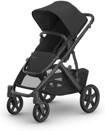 UPPAbaby Vista V3 stroller in charcoal color with bassinet attachment on a city sidewalk
