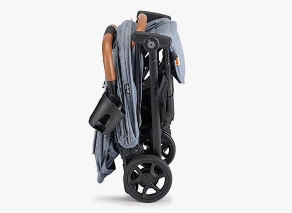 Zoe The Traveler stroller in black with bumper bar carry handle at an airport departure gate