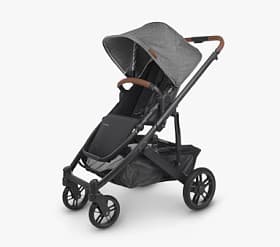 UPPAbaby Cruz V2 stroller in charcoal with toddler seat forward-facing on a city street