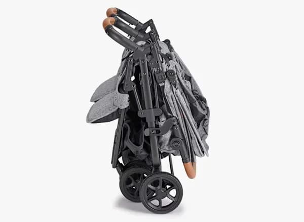 Zoe Twin+ lightweight side-by-side double stroller in slate color folded compactly at an airport gate