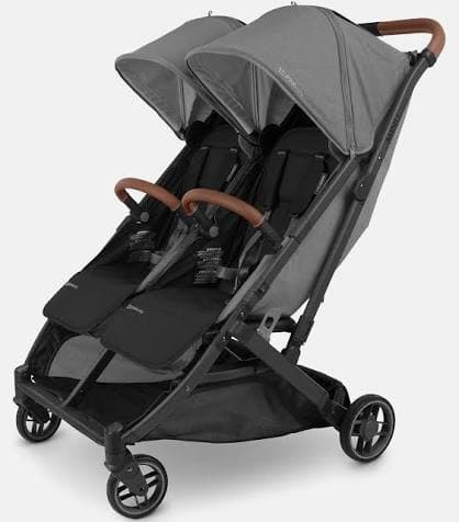 UPPAbaby Minu Duo compact side-by-side double stroller in grey melanito color on an urban sidewalk
