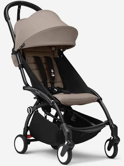 Babyzen YOYO3 stroller in white frame with navy color pack folded over shoulder at airport gate