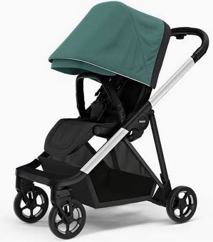 Thule Shine stroller in midnight black with adjustable handlebar raised and parent-facing seat in a Scandinavian urban setting