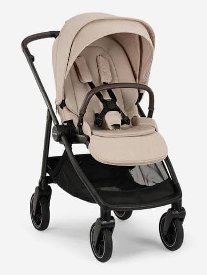 Nuna SWIV stroller in hazel tan with the rotating seat in forward-facing position on a city street