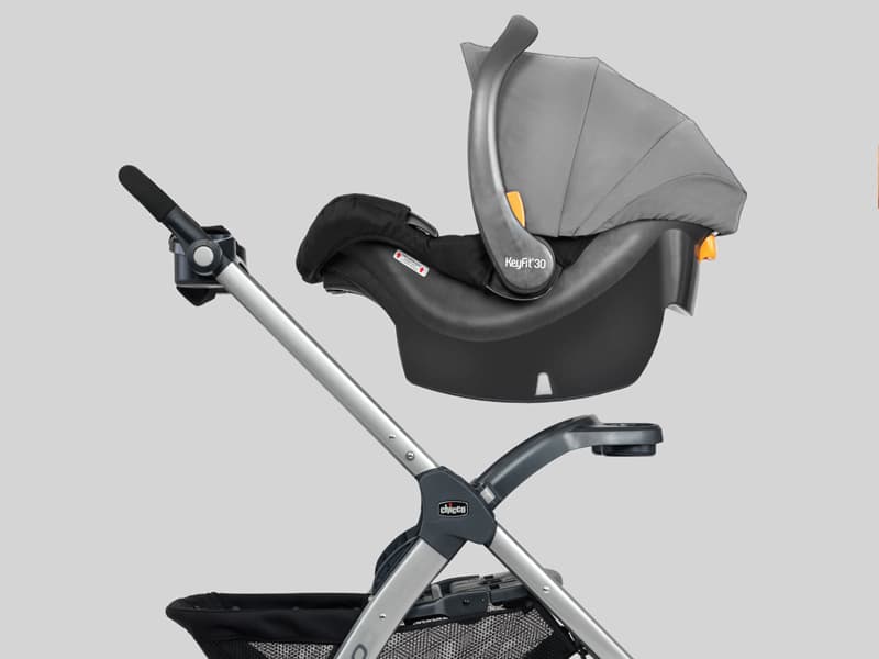 Chicco MiniBravo stroller in sand color with KeyFit infant car seat attached in a suburban driveway