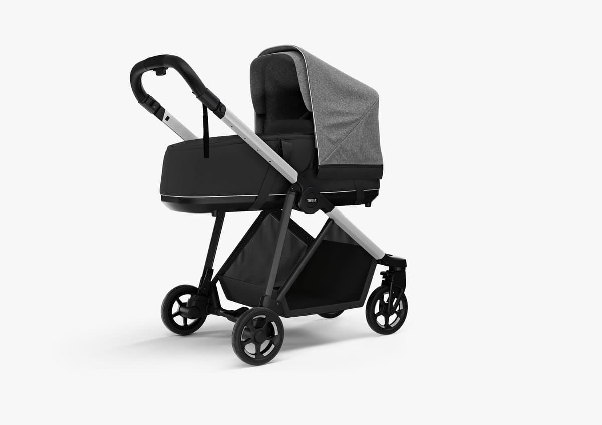 Thule Shine stroller in midnight black with adjustable handlebar raised and parent-facing seat in a Scandinavian urban setting