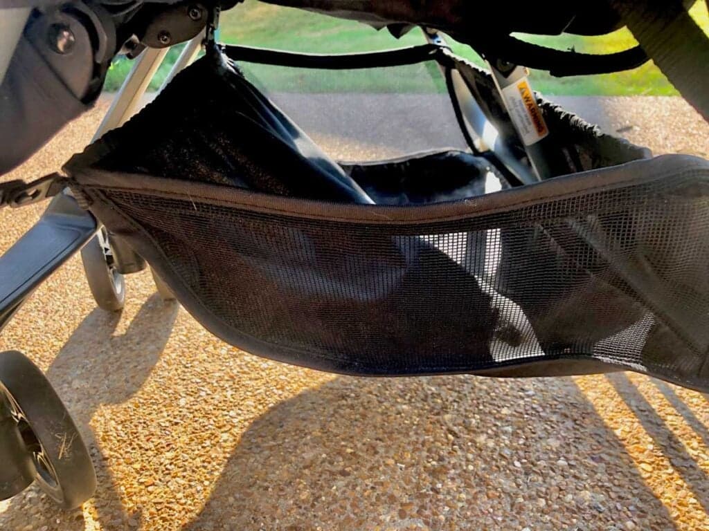 Zoe Twin+ lightweight side-by-side double stroller in slate color folded compactly at an airport gate