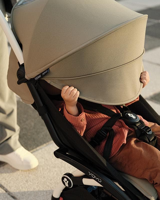 Stokke YOYO3 stroller in white frame with teal color pack folded to carry-on size at airport