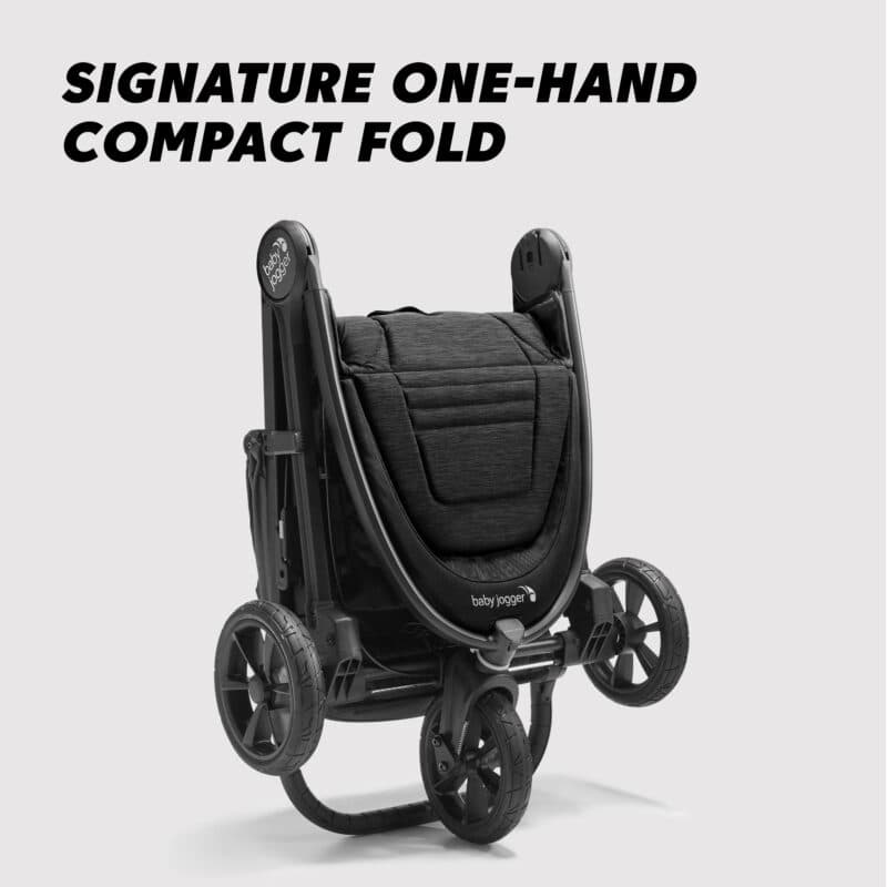 Baby Jogger City Mini GT2 stroller in black on a city sidewalk with all-terrain wheels