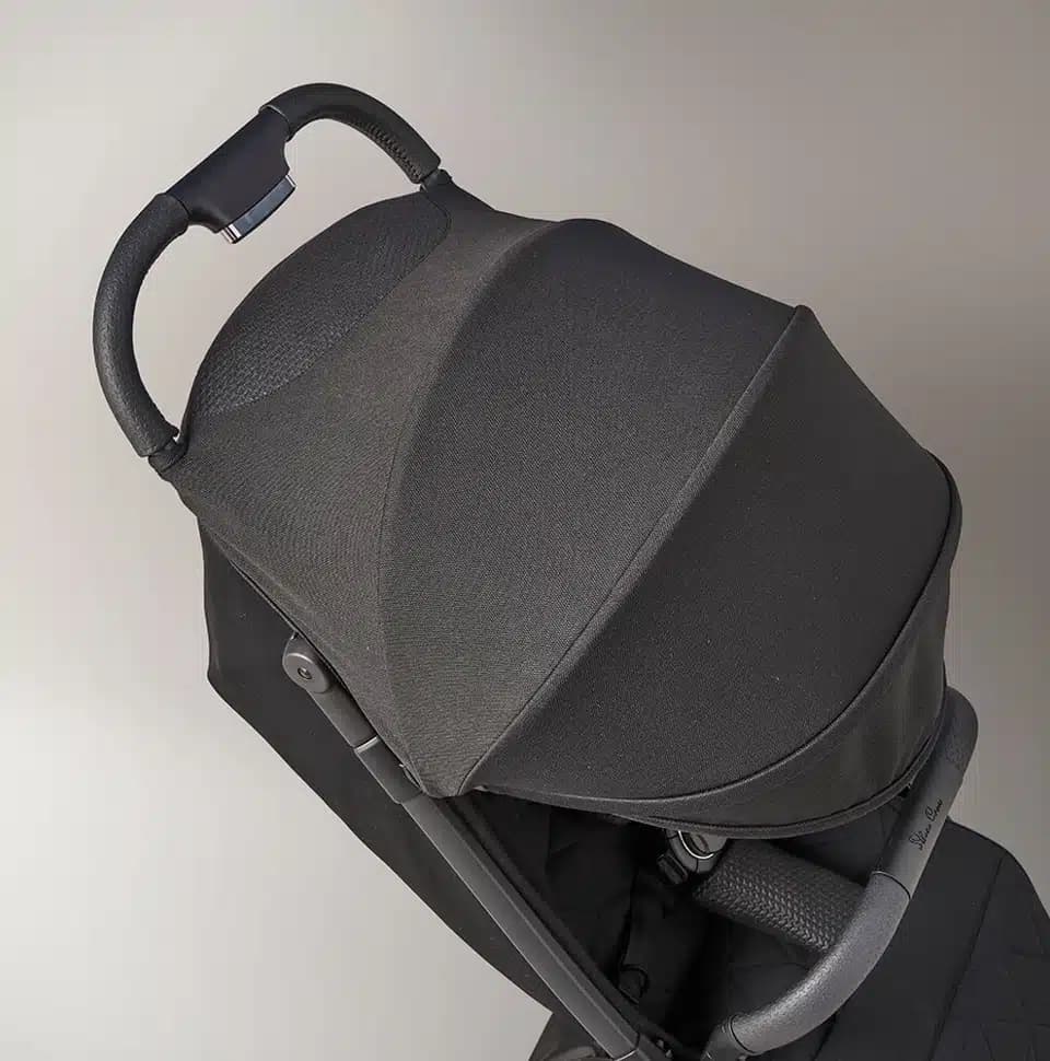 Silver Cross Clic stroller in stone color with lie-flat seat at an airport terminal gate